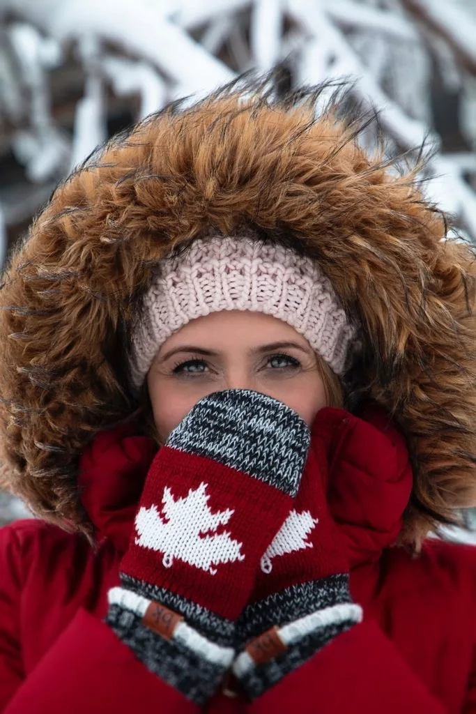 Woman Drinking Coffee With A Hood Up Trying To Keep Warm In The Snow